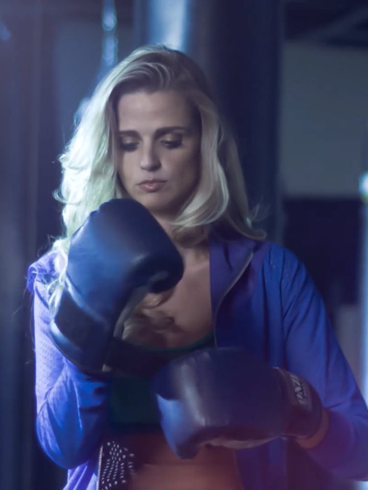 Atleta calçando luvas de boxe em academia, cena de filme publicitário
