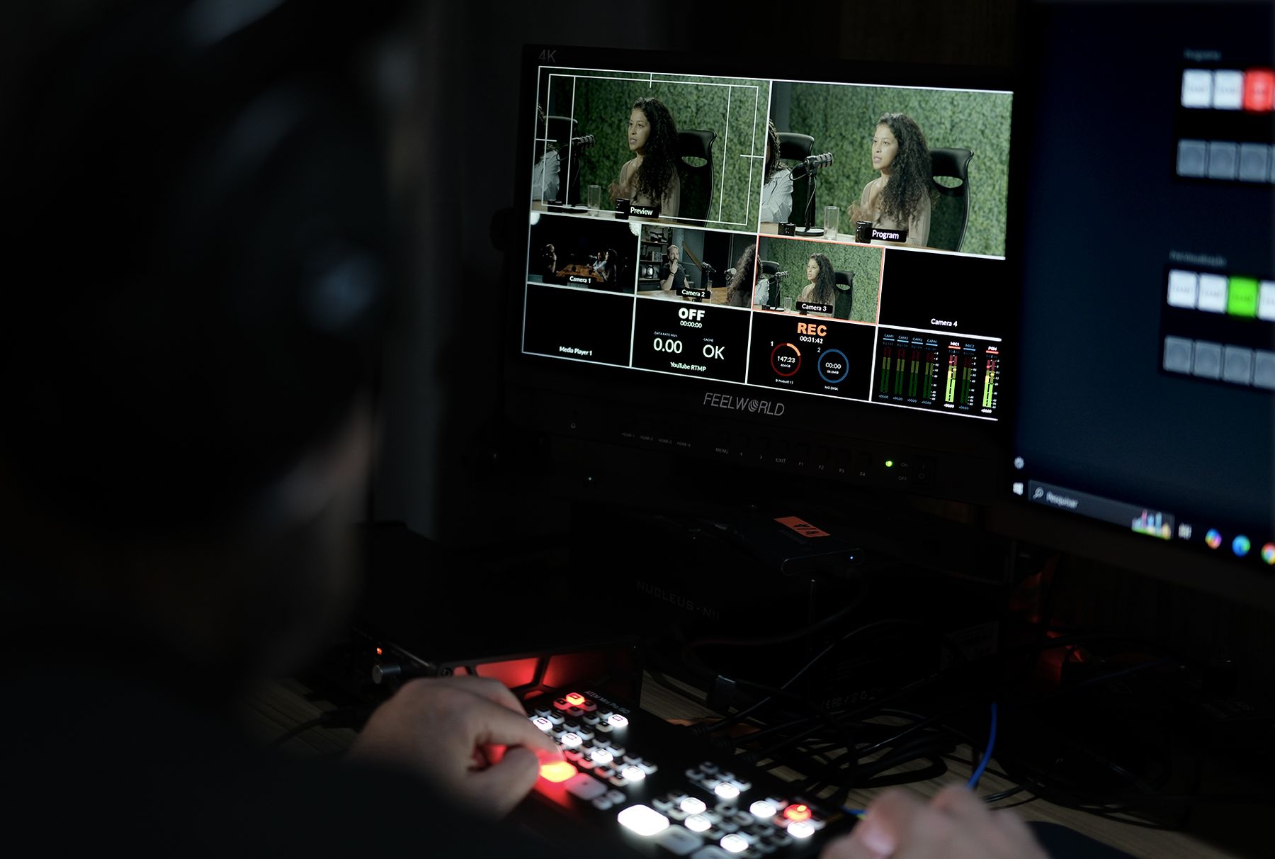 Operador fazendo corte em tempo real no switcher ATEM com monitor multiview de quatro câmeras