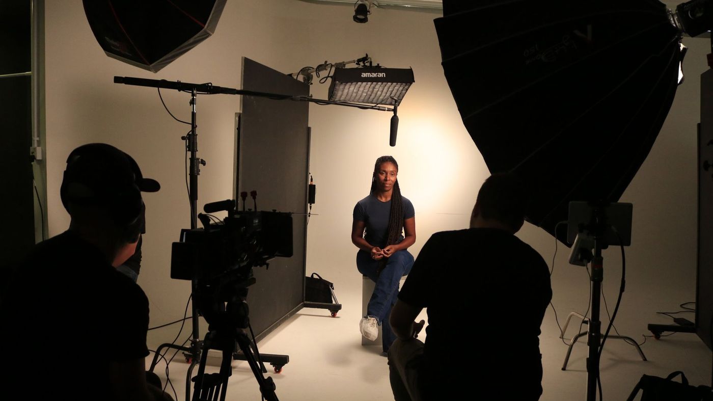 Gravação de depoimento em estúdio com fundo branco, softboxes, painel Amaran e microfone boom