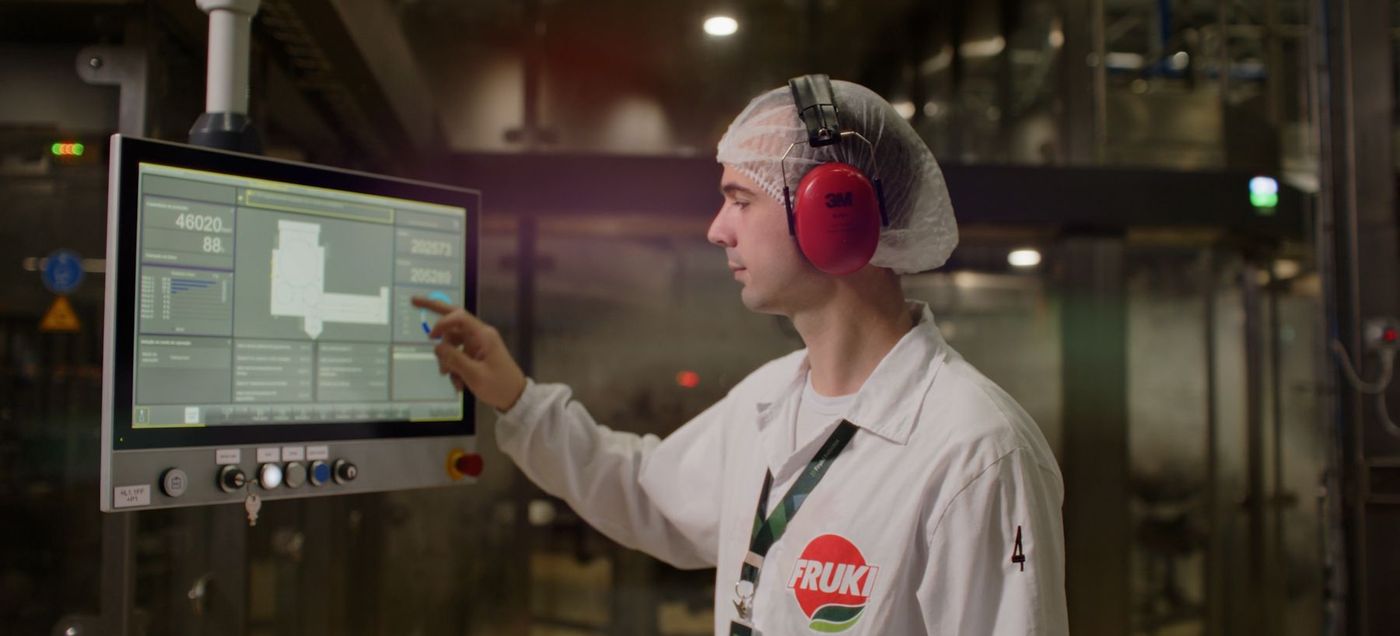 Operador em painel de controle na fábrica da Fruki, cena de vídeo institucional