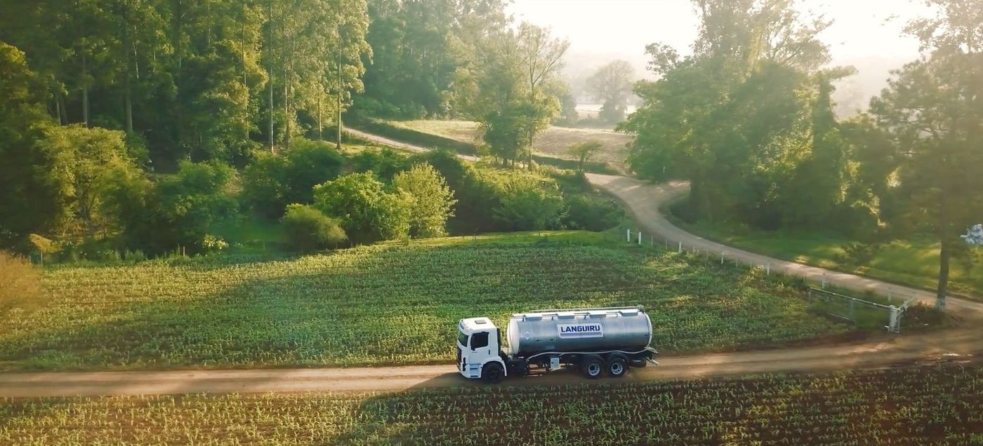 Caminhão de leite da Cooperativa Languiru em estrada rural, imagem aérea de drone do vídeo institucional